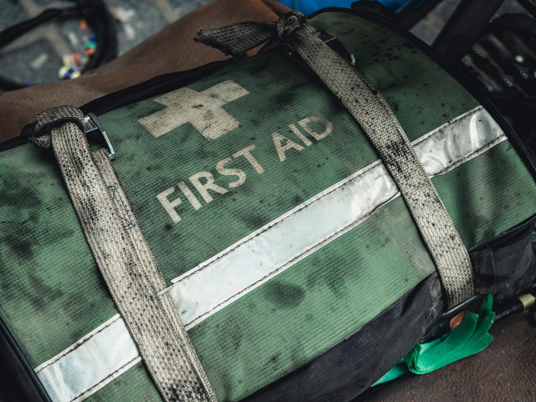 Green and black first aid bag on a surface