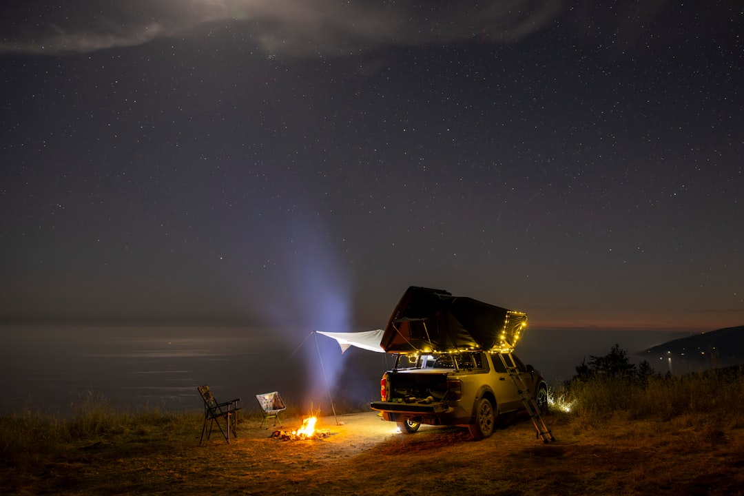4x4 truck with rooftop tent parked under a clear night sky