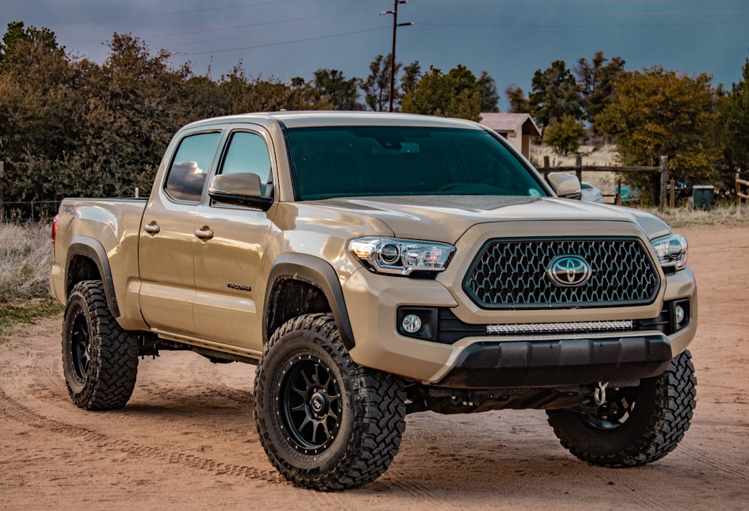 White Toyota crew cab pickup truck parked on a dirt trail with gear loaded for overlanding